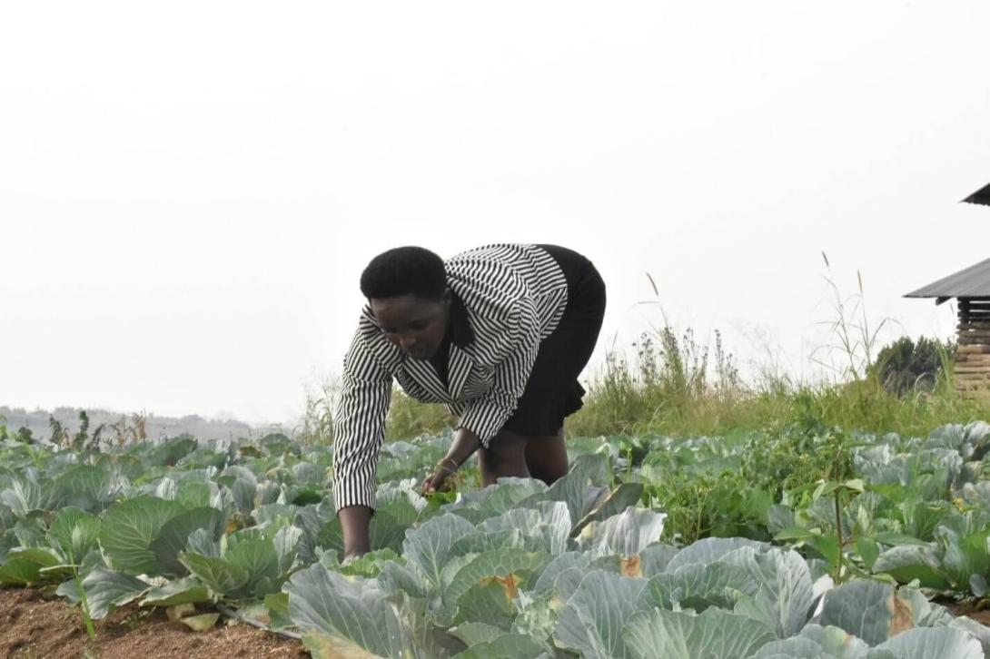Enid Kyarisima inspects a demonstration garden at the Lucky Nursery School, an ECD Center in Kyaka II Refugee Settlement